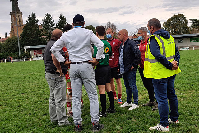 L'arbitre et le représentant fédéral (de dos) ont appelé capitaines, entraîneurs et dirigeants sur la pelouse pour les informer de sa décision. - Photo © Jean-Paul Epinette