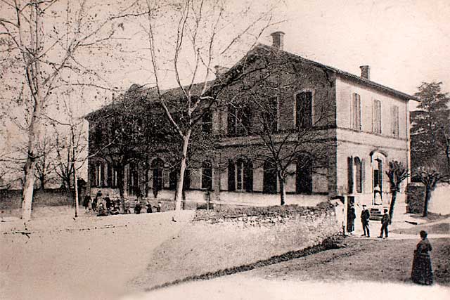 La Maison d'école fut construite en 1871. Le préau et le mur de la cour en 1877. - Le bâtiment fut construit  en 1871,  dans le  haut de la ville. Le préau et le mur séparant la cour de la rue le furent en 1877.